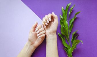 vrouwelijke manicure op een lichte achtergrond. Purper foto