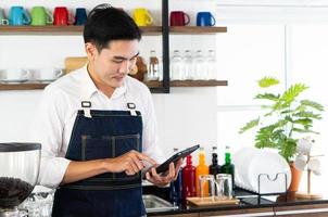 jonge Aziatische barista die de bestelling van koffie in café opneemt? foto