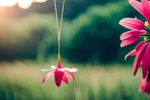 een roze bloem hangende van een ketting in de gras. ai-gegenereerd foto