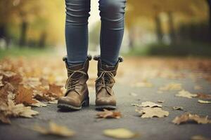 vrouw in jeans en laarzen wandelen Aan herfst park. detailopname van de voeten. herfst mode concept, herfst tendens. generatief ai foto