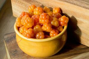 bergbraambes rubus koor dichtbij omhoog in oranje kom Aan houten tafel foto