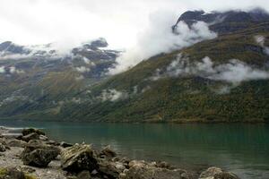 Noors landschap in herfst in de buurt lenen en stryn in Noorwegen, lovatnet in oktober, meer met turkoois water en laag wolken foto