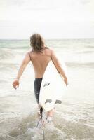 surfer Mens met zijn surfboard Aan de strand. foto