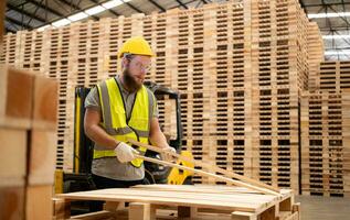 portret van jong mannetje timmerman werken in een houtbewerking fabriek, hij is vervelend een veiligheid helm en bril, controle de houten planken komt eraan uit van de hout Slijper. foto