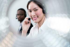 groep van bedrijf mensen vervelend koptelefoon werken actief in kantoor. telefoontje centrum, telemarketing, klant ondersteuning middel voorzien onderhoud Aan telefoon video conferentie telefoongesprek. foto