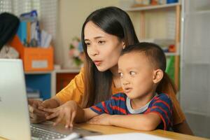 moeder en zoon aan het kijken films Aan computer Bij huis tafel foto