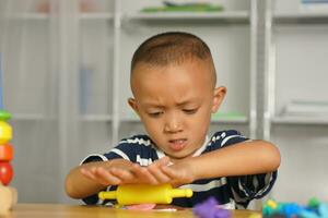 een jongen kneedt plasticine naar maken dingen zacht. foto