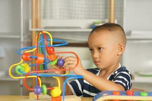 jongen spelen met ontwikkelingsstoornissen speelgoed Aan tafel Bij huis foto