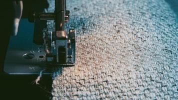 een naaimachine naait jute stof. kleding van hennepstof naaien. foto