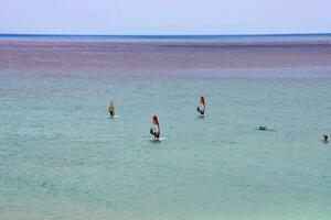 meerdere mensen het windsurfen in de oceaan foto