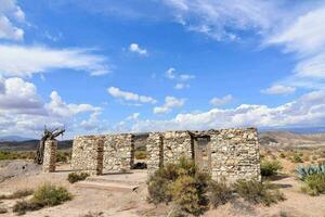 een oud steen gebouw in de woestijn met een blauw lucht foto