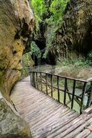 een houten loopbrug Leidt naar een grot in de bergen foto