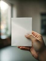 een hand- Holding een stuk van duidelijk wit papier met een wazig achtergrond, ai gegenereerd. foto