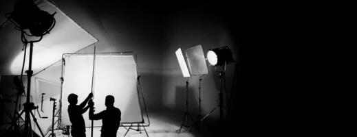 silhouet van video productie achter de scènes of b rollen of maken van TV reclame film dat film bemanning team licht man en cameraman werken samen met regisseur in groot studio met pro uitrustingen foto