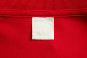 blanco wit wasserij zorg kleren etiket Aan rood overhemd kleding stof structuur achtergrond foto