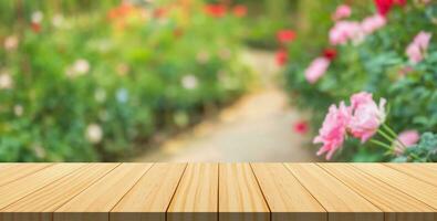 leeg hout tafel top met vervagen roos tuin achtergrond voor Product Scherm foto