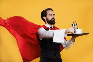 elegant butler dragen bord naar dienen diner, vervelend rood superheld kaap tegen geel achtergrond. professioneel ober Bij restaurant Holding voedsel dienblad, presentatie van krachtig bezigheid. foto