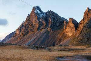 Vestrahorn rotsachtig bergen Aan stokksnes strand, majestueus landschap De volgende naar natuurlijk zwart zand strand. spectaculair IJslands natuur met steen kliffen en heuvels, nordic toneel- route. foto