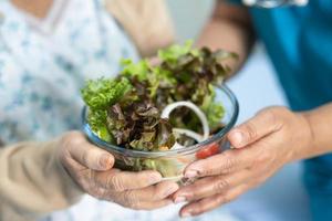 Aziatische senior vrouw patiënt eten ontbijt foto