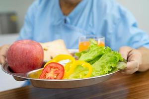 Aziatische senior vrouw patiënt eten ontbijt foto