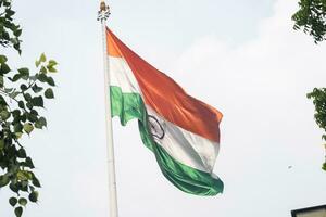 indiase vlag hoog op connaught plaats met trots in blauwe lucht, indiase vlag wapperen, indiase vlag op onafhankelijkheidsdag en republiek dag van india, tilt-up shot, wuivende indische vlag, har ghar tiranga foto