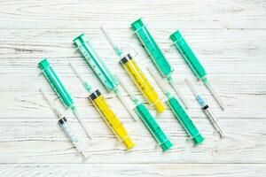 top visie van veel injectiespuiten bereid voor injectie Bij houten achtergrond. behandeling concept met kopiëren ruimte foto