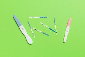 gekleurde zwangerschap test Aan gekleurde achtergrond, top visie met kopiëren ruimte foto