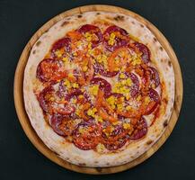 pizza peperoni met tomaten en maïs foto