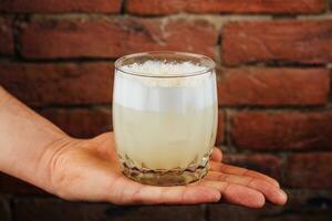 cocktail met limoen en wit schuim in een glas glas foto