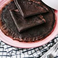 chocola pannenkoek Aan roze bord dichtbij omhoog foto