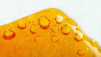 cannabishars loopt langs het papier, bubbels wax met hoge thc foto