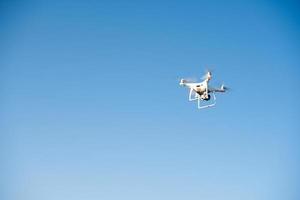 witte drone vliegt in de lucht en neemt een video op foto