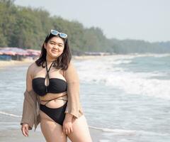 portret jong vrouw Aziatisch mollig dik schattig mooi een persoon in bikini zwart sexy vooraanzicht tropisch zee strand wit zand schoon en blauw lucht achtergrond kalmte natuur oceaan Golf water reizen pret gelukkig foto