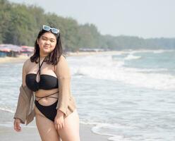 portret jong vrouw Aziatisch mollig dik schattig mooi een persoon in bikini zwart sexy vooraanzicht tropisch zee strand wit zand schoon en blauw lucht achtergrond kalmte natuur oceaan Golf water reizen pret gelukkig foto