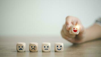 cliënt tevredenheid terugkoppeling opnieuw bekijken. wereld mentaal Gezondheid dag. klanten plukken houten etiketten met smiley gelukkig en ontspannen gezichten. mooi zo partituur beoordeling, denken positief mentaal staat Gezondheid. foto