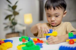 de kind spelen met kleurrijk speelgoed- blokken. weinig jongen gebouw de auto van blok speelgoed. leerzaam en creatief speelgoed en spellen voor jong kinderen. foto