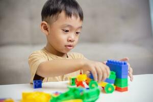 de kind spelen met kleurrijk speelgoed- blokken. weinig jongen gebouw de auto van blok speelgoed. leerzaam en creatief speelgoed en spellen voor jong kinderen. foto