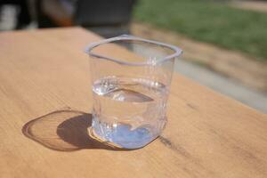 vers drinken water in een plastic houder Aan tafel foto
