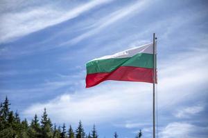 Bulgaarse nationale vlag op een paal tegen zijdeachtige wolken.