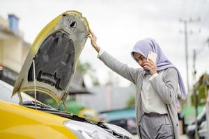 portret van aziatische vrouw die bezig is reparatiewerkplaats te bellen voor service foto