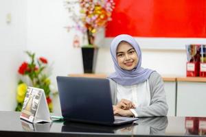 portret van een aziatische vrouw die lacht voor een laptop foto