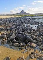 vulkanische piek op een afgelegen eilandkust foto