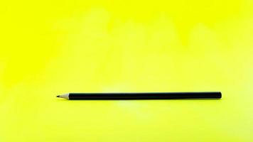 zwart potlood op geel papier achtergrond. foto