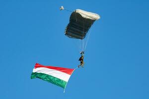 parachutist vliegend in de lucht. extreem sport en x Games. jumping met Hongaars vlag. foto
