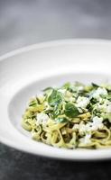 gastronomische biologische Italiaanse ricotta en verse gemengde kruiden tagliatelle op bord