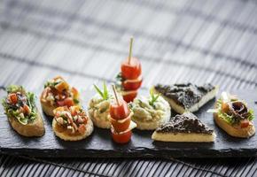 spaanse gastronomische creatieve tapas gemengde snackschotel op tafel foto