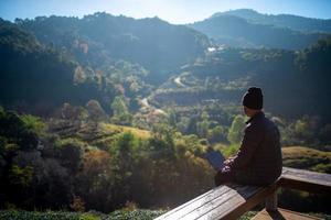 reiziger gebruikt laptop in de ochtend, berglandschap foto