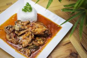Baskische stijl pittige 3 kip en groente stoofschotel maaltijd op houten tafel foto