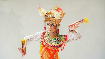 meisje vervelend balinees traditioneel jurk met een dansen gebaar Aan wit achtergrond met in de hand gehouden fan, kroon, sieraden, en goud ornament accessoires. geïsoleerd balinees danser vrouw portret foto