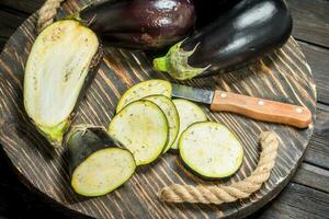 stukken van aubergine Aan een snijdend bord met een mes. foto